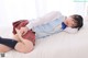 A woman in a school uniform laying on a bed.