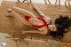 A woman in a red bikini laying on a wooden table.