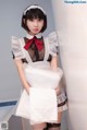 A woman in a maid outfit is posing for a picture.