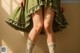 A woman in a green dress and knee high socks.