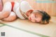 A woman in a red and white bikini laying on a tatami mat.