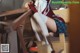 A woman in a school uniform is sitting on a chair.